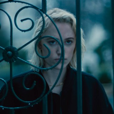 Woman looking through an ornate iron gate