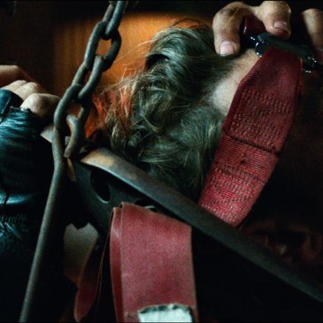 close up of man's head being strapped to a chair