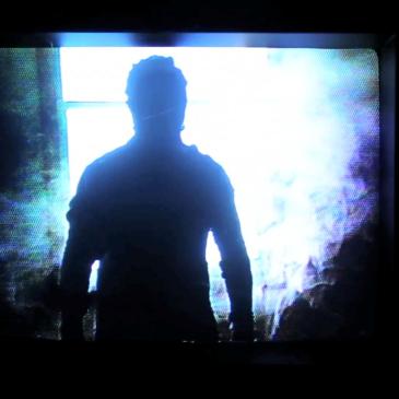 a dark figure standsin front of a window in silhouette