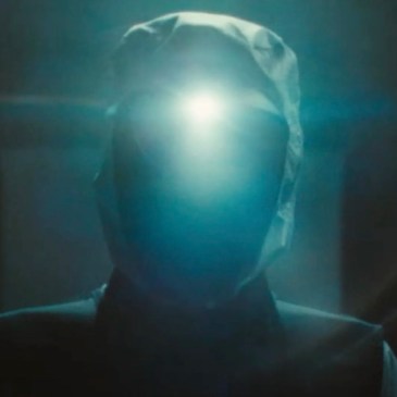 hooded man in shadow with light on his head