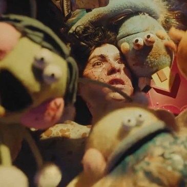 person with blood on their face surrounded by puppets
