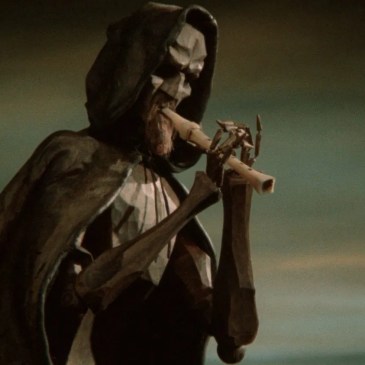 Hooded man playing a flute
