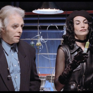a man and a woman stand in front of science equipment