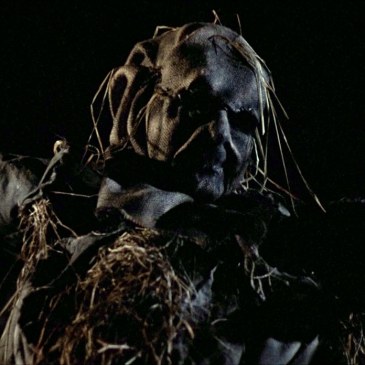 scarecrow with burlap sack face and outstretched arms